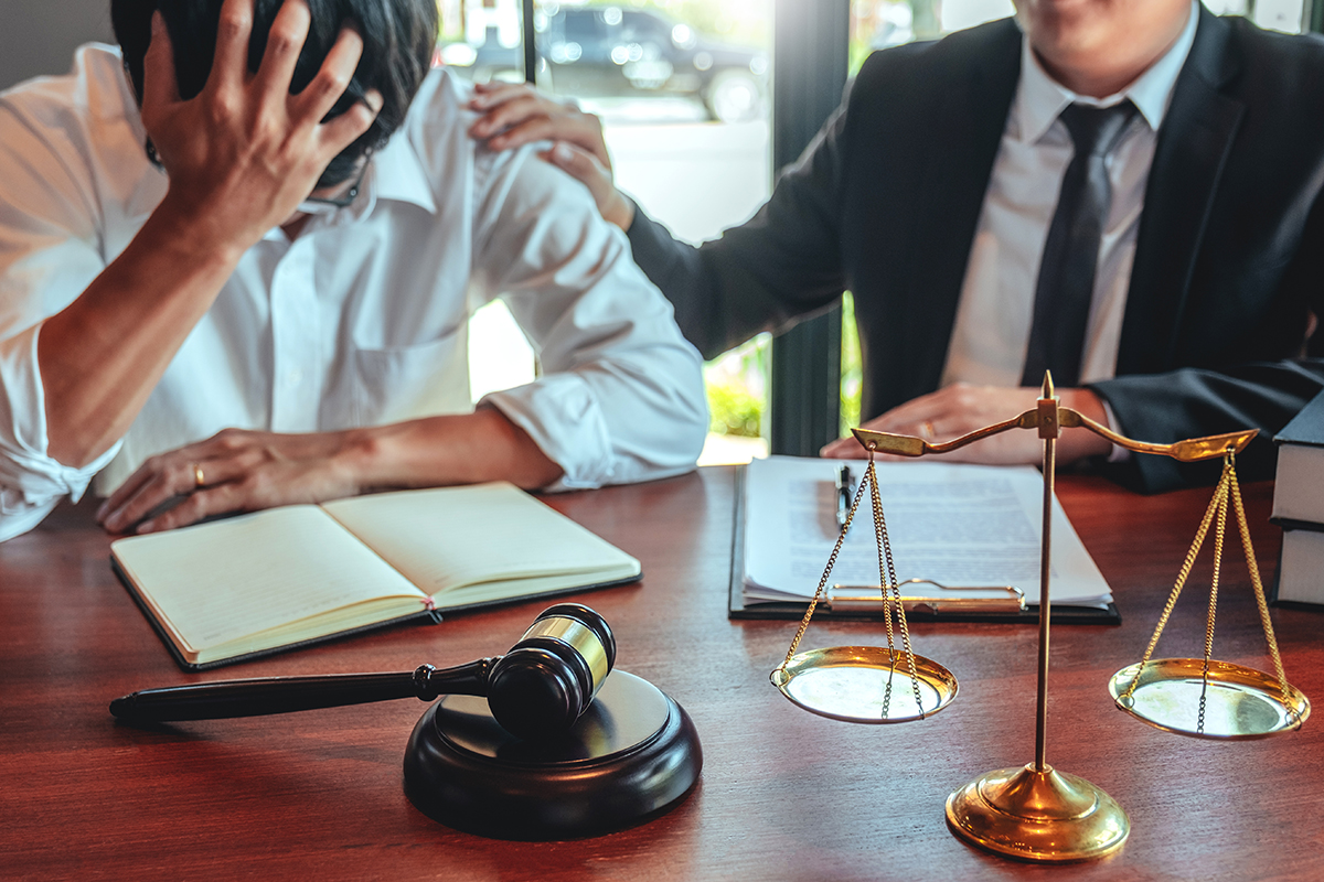 Bankruptcy lawyer comforting a stressed client during a debt consultation